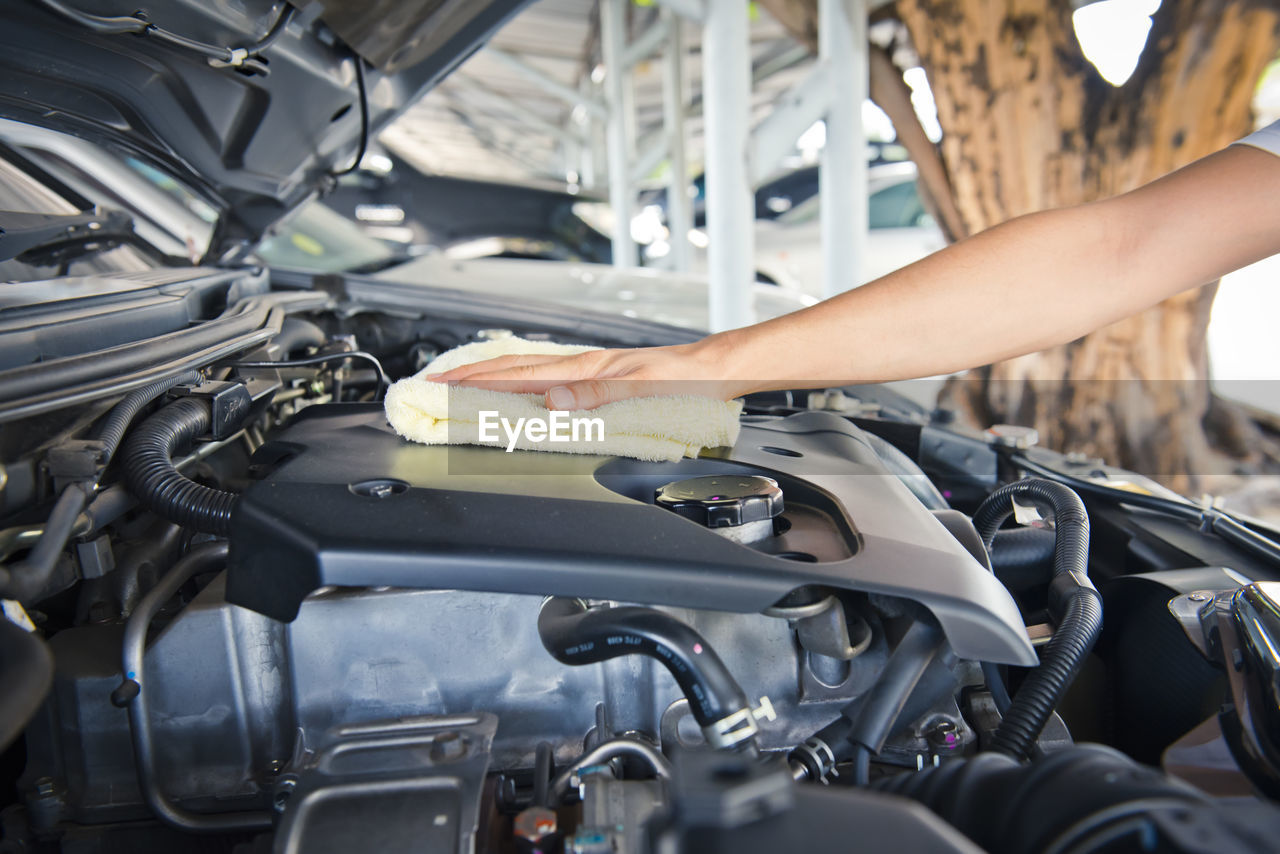 Hand cleaning car engine with a rag,worker
