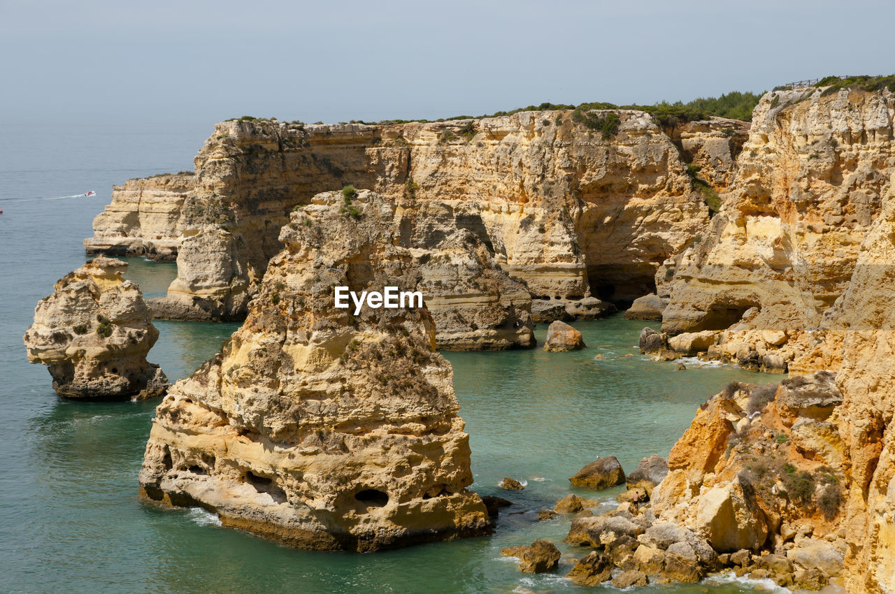 Rock formations by sea against sky