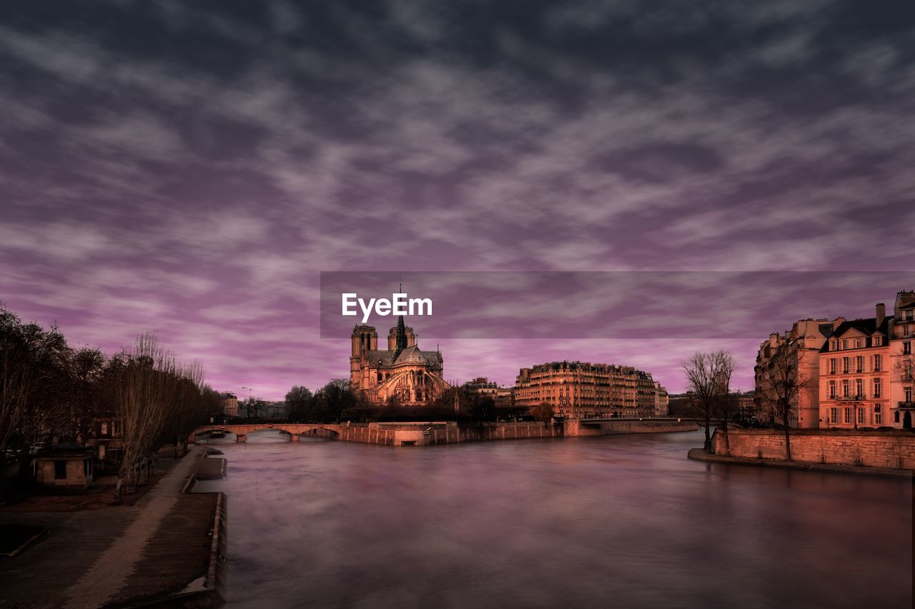 VIEW OF RIVER AMIDST BUILDINGS AGAINST SKY