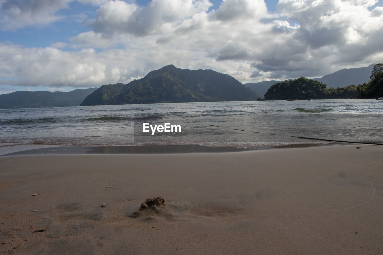 land, water, sky, body of water, beach, sea, cloud, scenics - nature, sand, mountain, shore, nature, beauty in nature, ocean, coast, environment, landscape, tranquility, travel destinations, horizon, wave, bay, travel, tranquil scene, no people, coastline, day, outdoors, wind wave, tourism, trip, holiday, vacation, island, non-urban scene, water's edge, mountain range