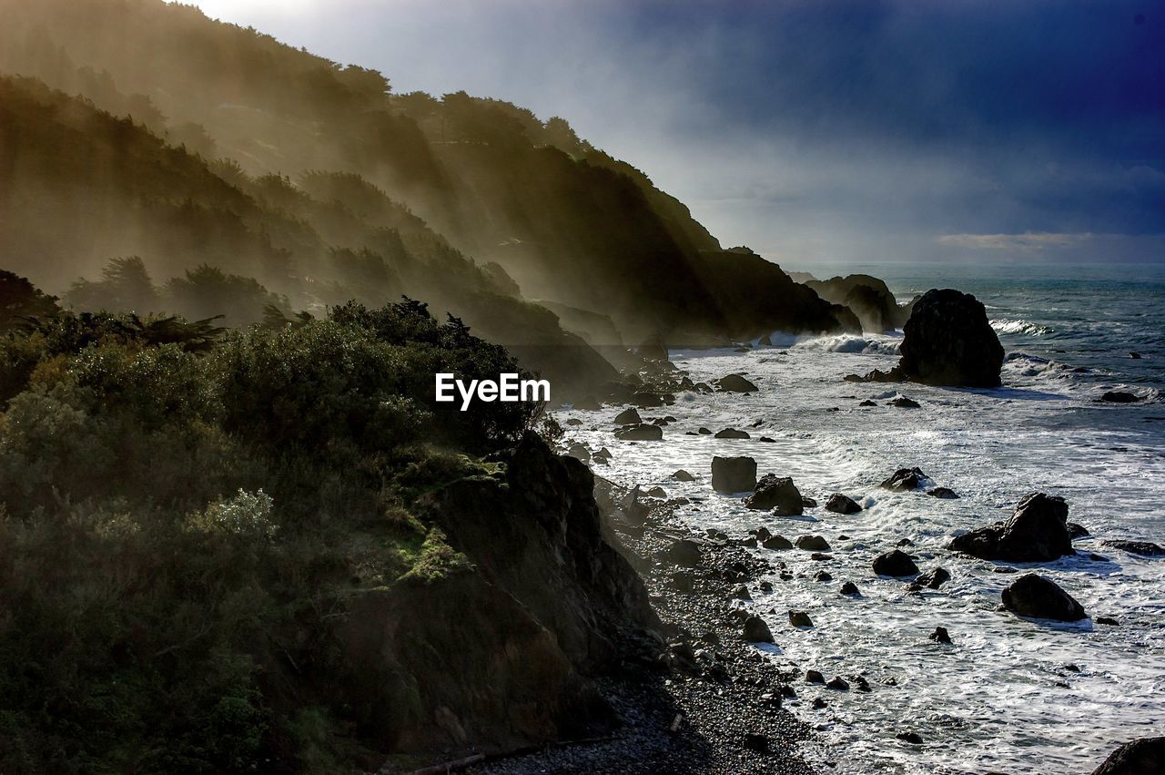 High angle view of mountains by sea during foggy weather