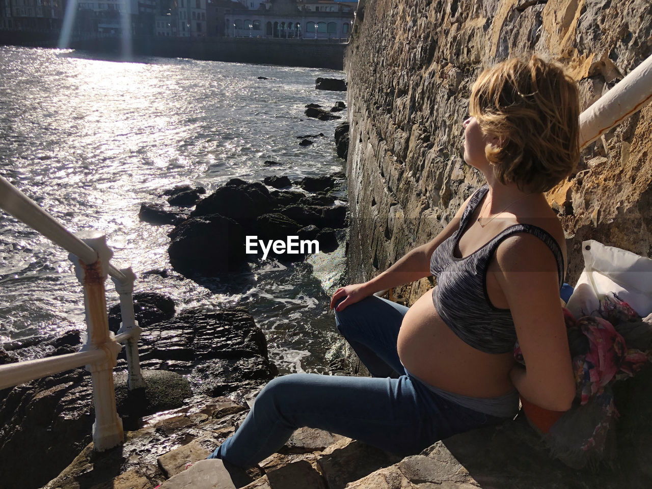 side view of woman sitting on rock
