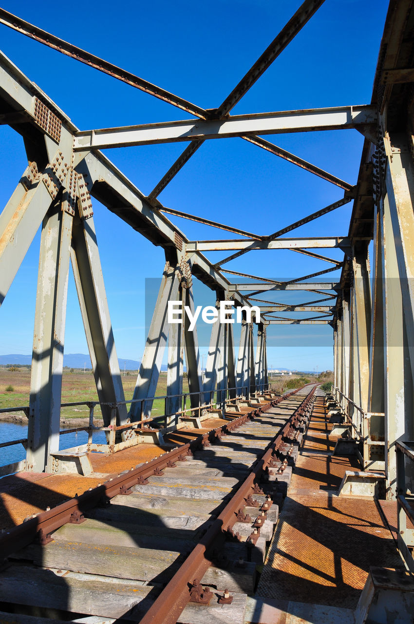 Metallic bridge against clear blue sky