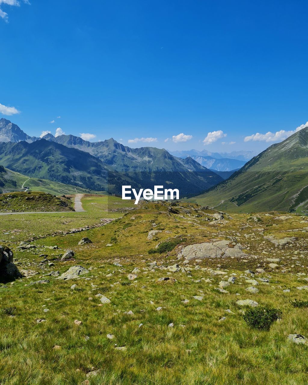 mountain, environment, landscape, scenics - nature, beauty in nature, sky, mountain range, wilderness, meadow, nature, grass, highland, land, grassland, plant, tranquil scene, snow, tranquility, walking, ridge, blue, non-urban scene, travel destinations, no people, travel, plateau, cold temperature, green, lake, pasture, plain, field, day, mountain pass, winter, cloud, valley, outdoors, idyllic, clear sky, adventure, snowcapped mountain, rural scene, tourism, sunlight, leisure activity, activity, mountain peak, backpacking, remote, sunny