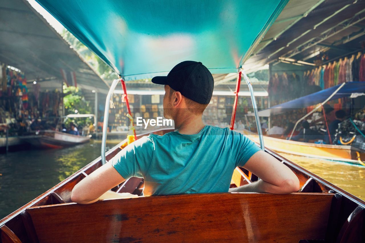 Rear view of man sitting in boat