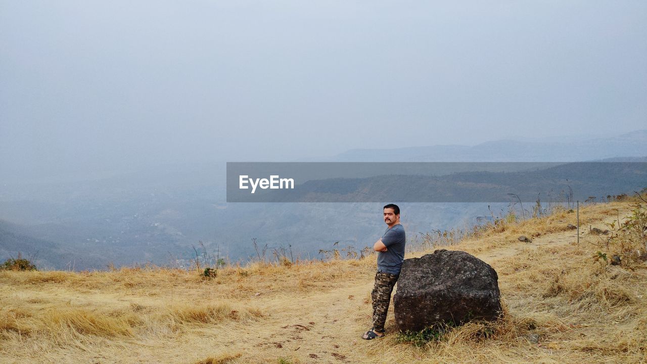 Man standing on mountain against sky