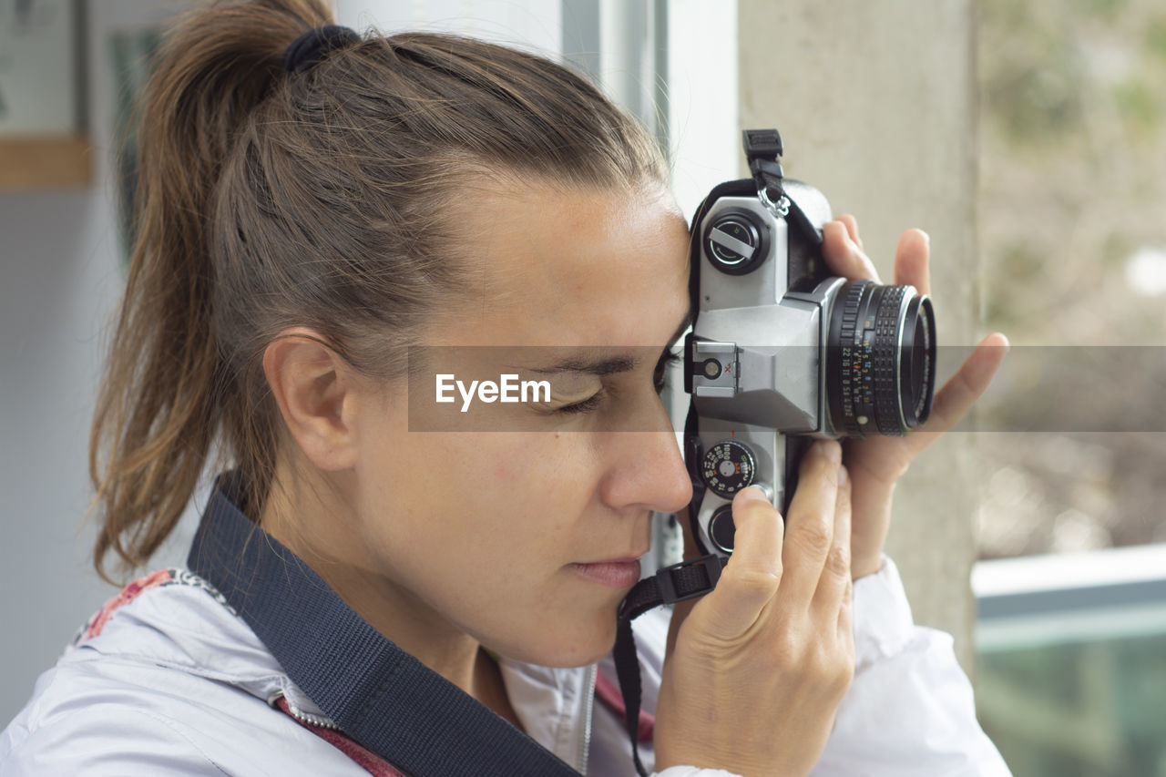 PORTRAIT OF WOMAN WITH CAMERA