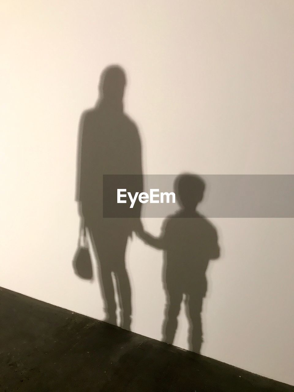 Shadow of mother with son on wall