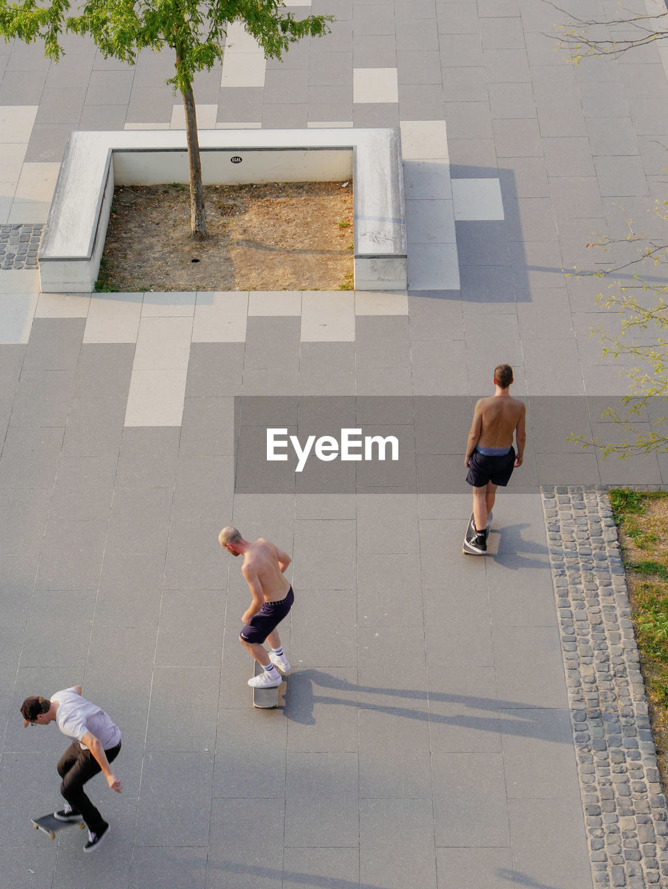 High angle view of friends skateboarding on street