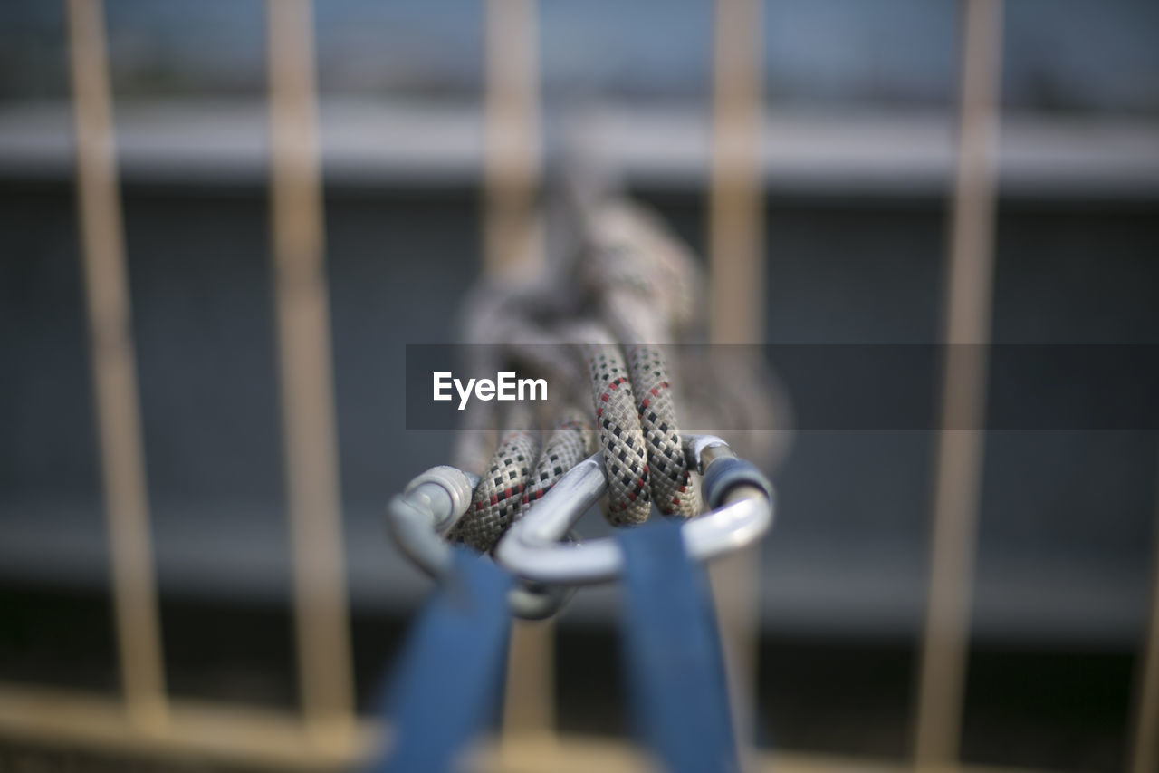 CLOSE-UP OF SPIDER HANGING ON METAL RAILING