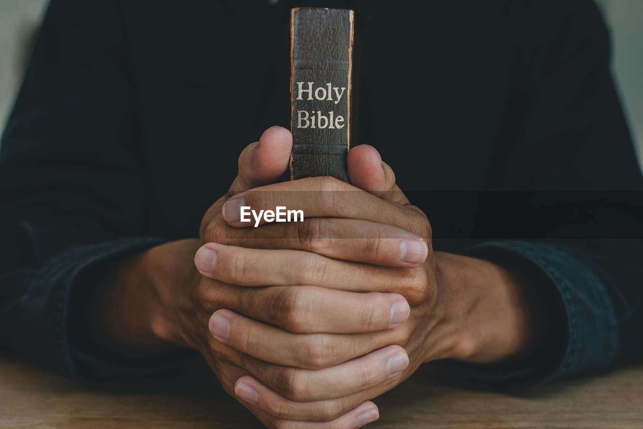 Midsection of man holding text on table