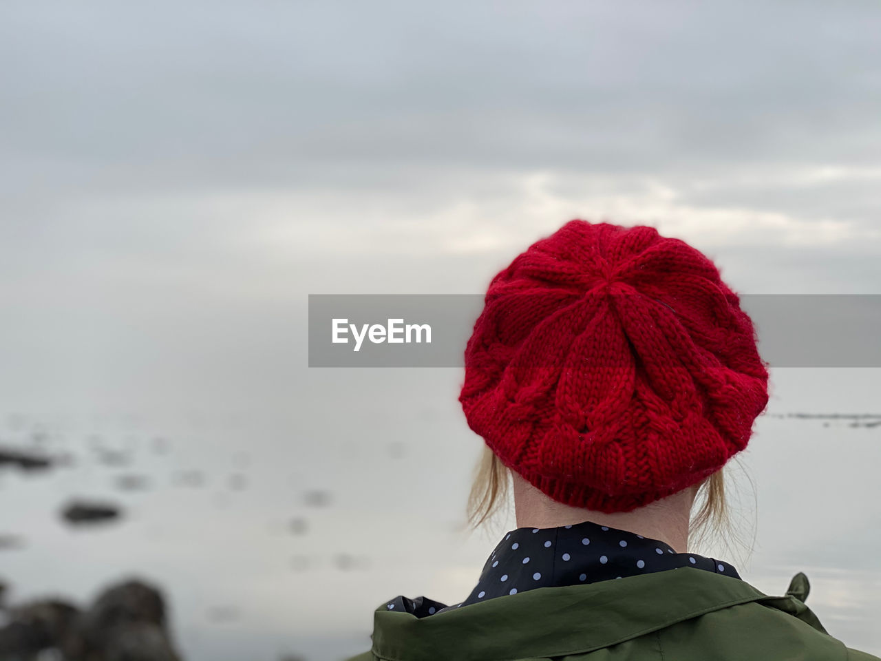 Rear view of woman with red knit hat against sky