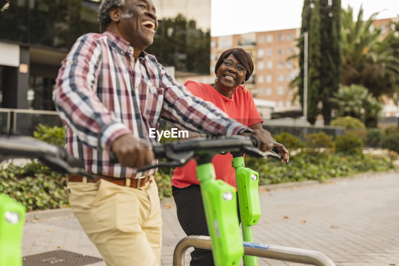 Happy senior couple spending leisure time with push scooters