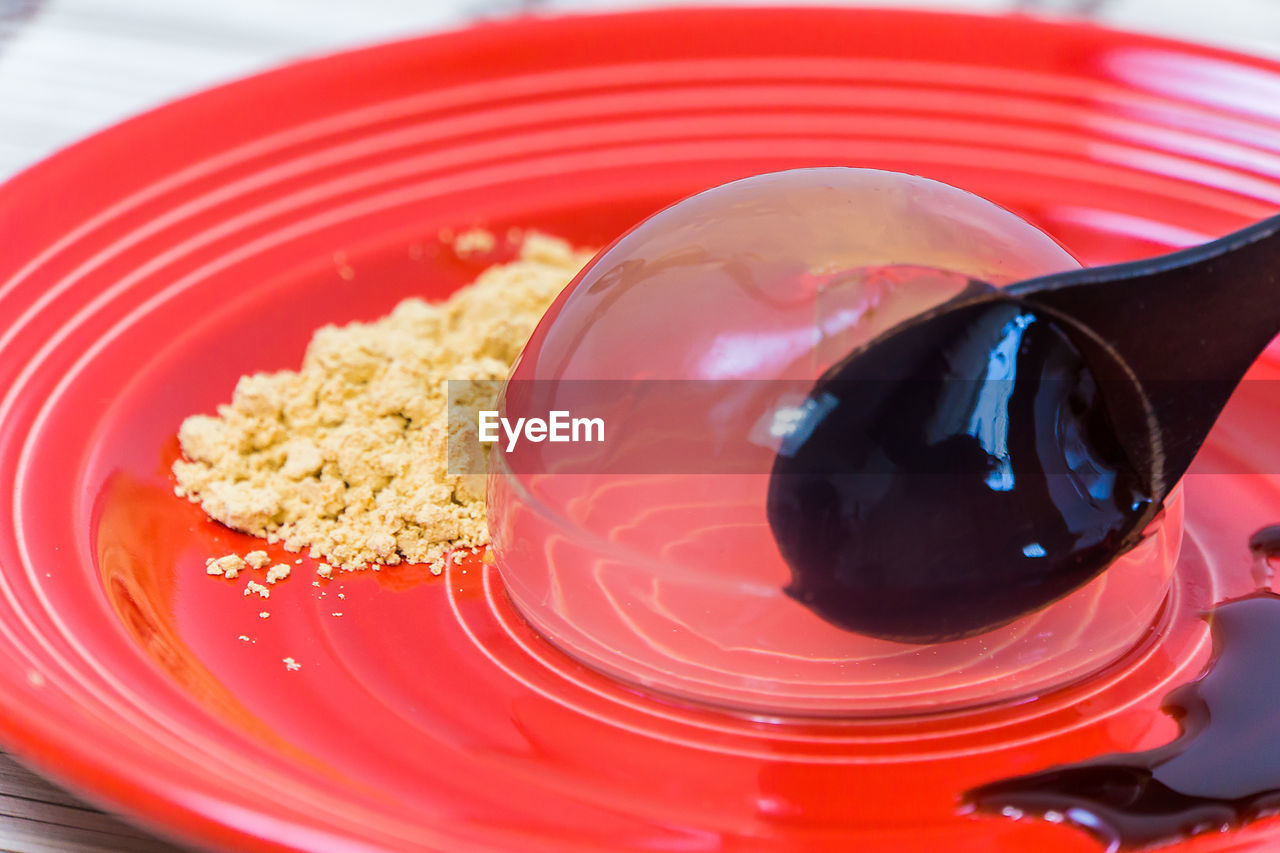 Close-up of raindrop cake served on red plate