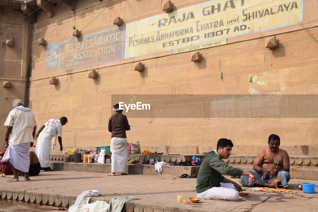 PEOPLE SITTING IN FRONT OF WALL