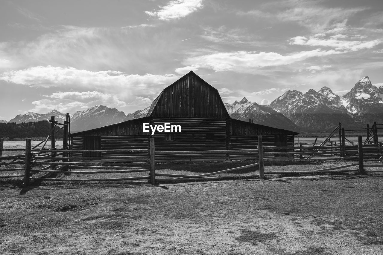 sky, architecture, black and white, built structure, cloud, monochrome, mountain, nature, monochrome photography, landscape, building exterior, snow, environment, hut, rural area, land, white, building, scenics - nature, wood, rural scene, day, outdoors, mountain range, beauty in nature, house, farm, fence, no people, travel destinations, winter