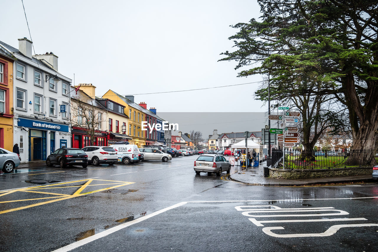 CARS ON ROAD AGAINST BUILDINGS IN CITY