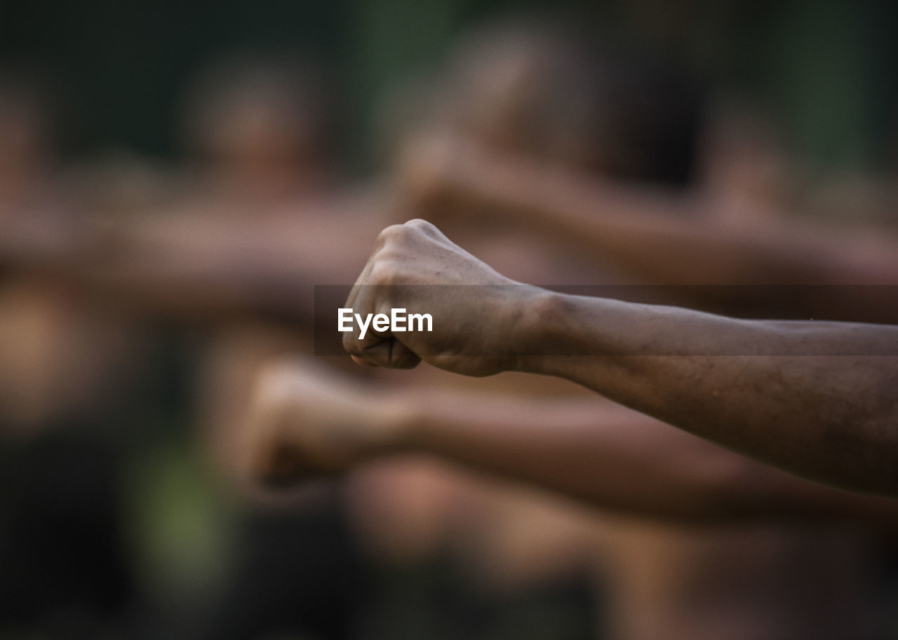 Cropped hands clenching fist