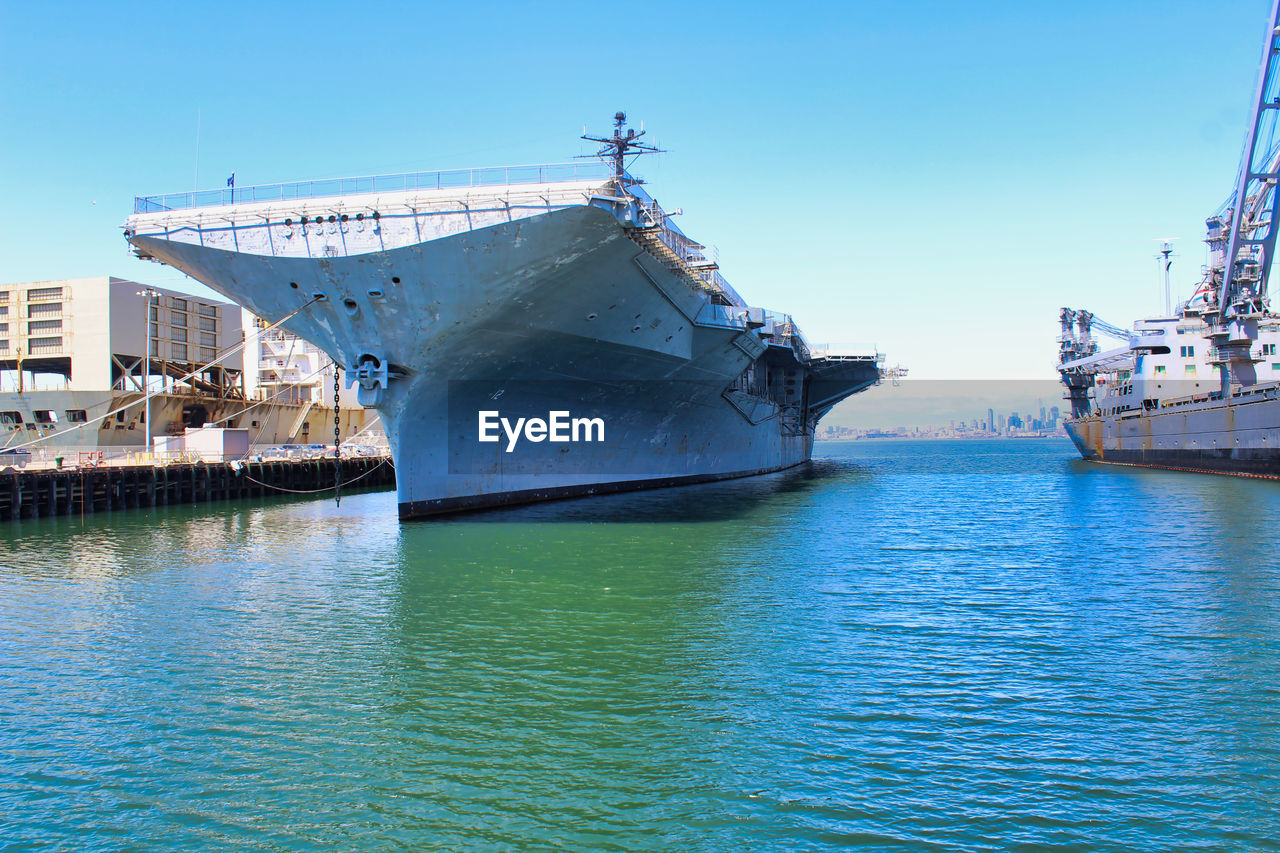 SHIP MOORED IN SEA AGAINST CLEAR SKY