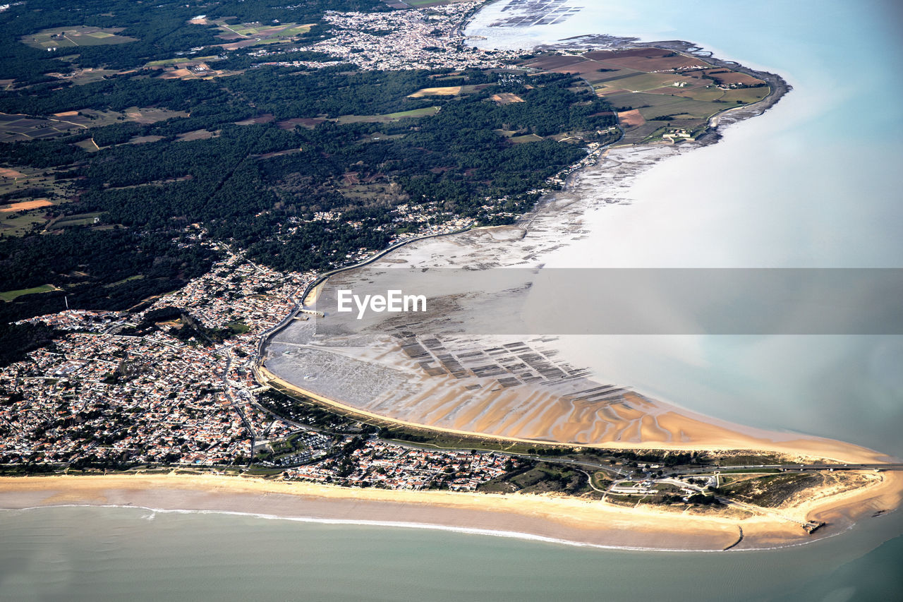 Aerial view of landscape and sea against cloudy sky