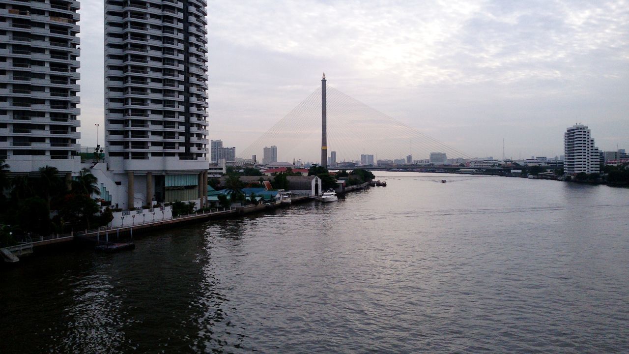 River by buildings against sky