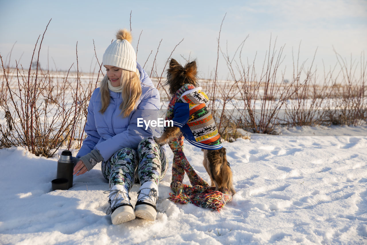 rear view of woman sitting on snow covered land