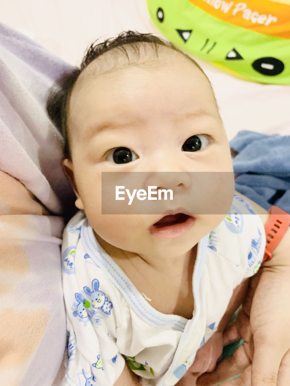 PORTRAIT OF CUTE BABY BOY LYING ON BED