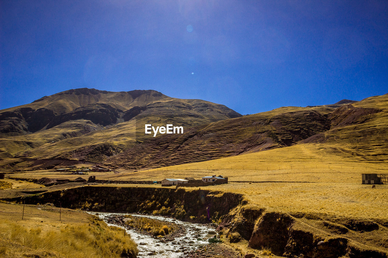 Scenic view of mountains against clear blue sky