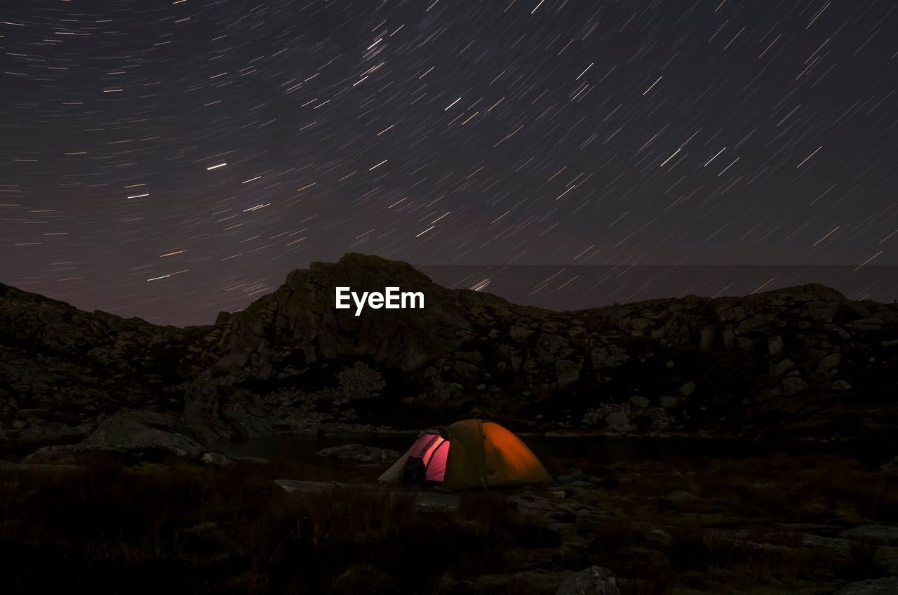 Tent at night with star trail in background