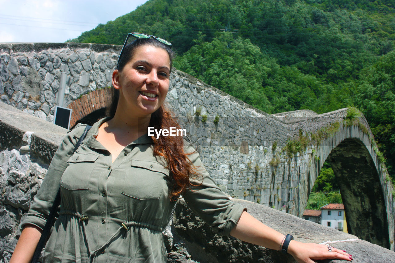 Caucasian tourist girl visiting the maddalena bridge in borgo a mozzano for the legend of the devil