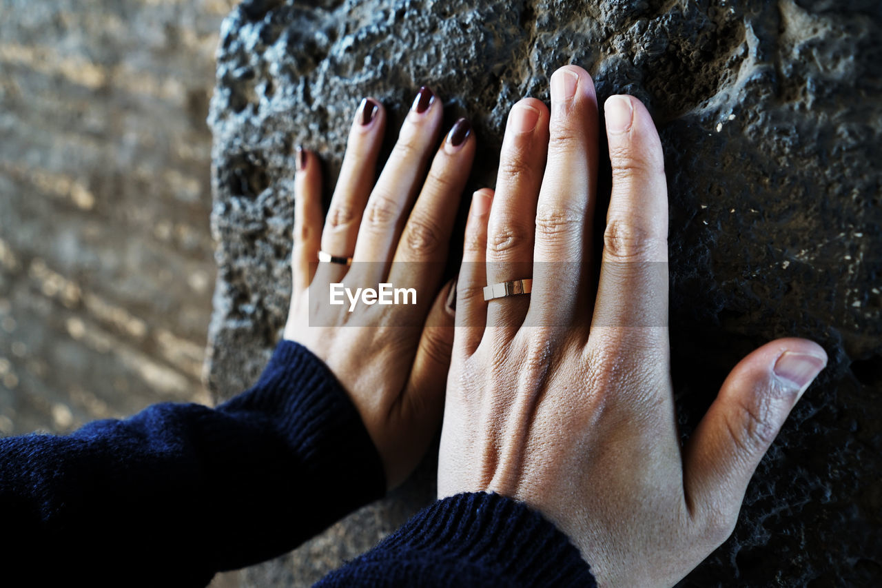 Close-up of couple touching rock