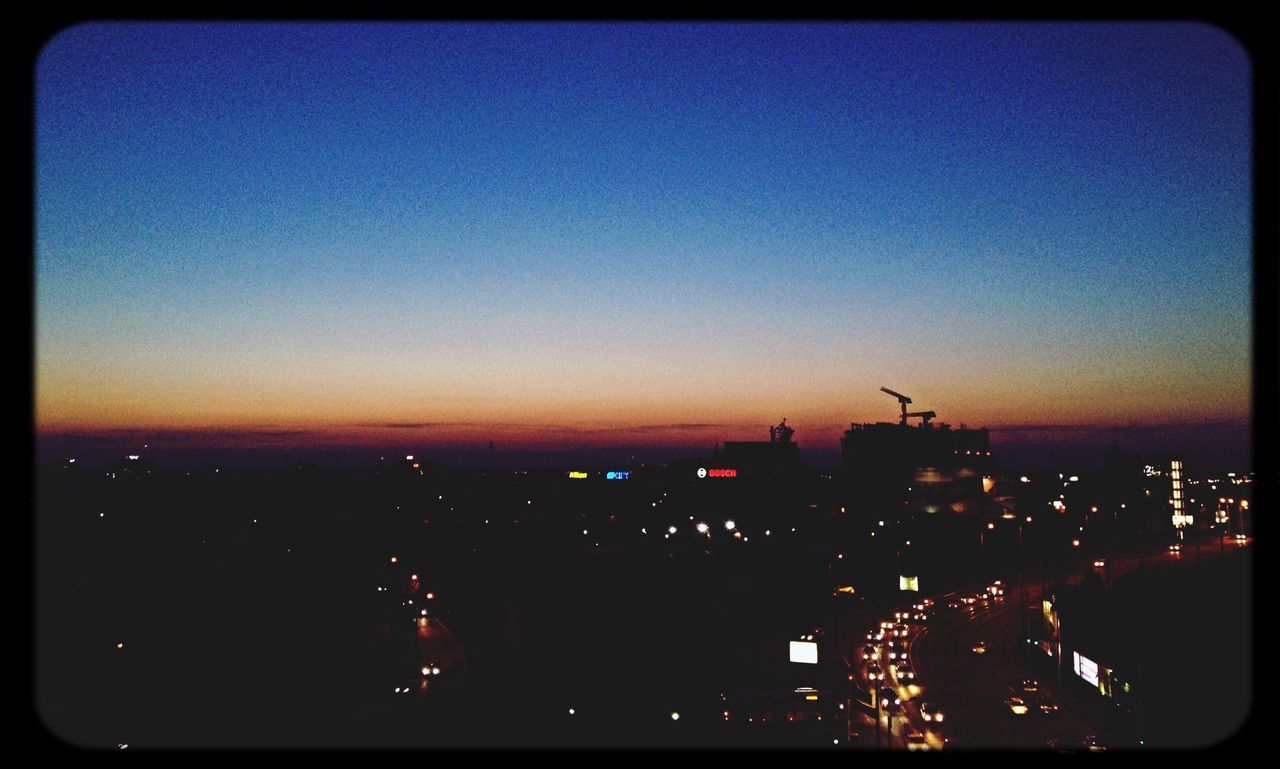 VIEW OF ILLUMINATED CITYSCAPE AT NIGHT