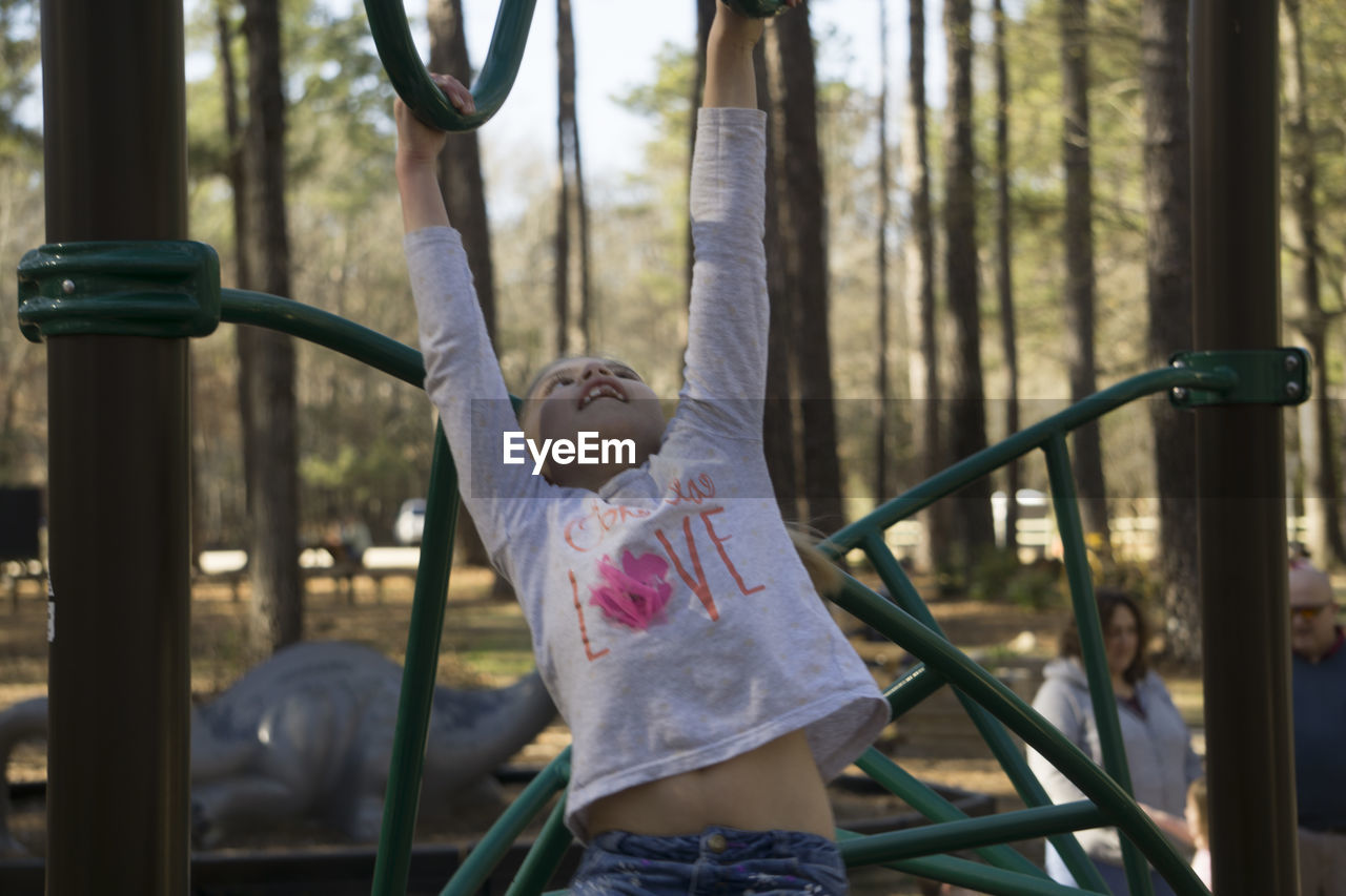 Girl playing on monkey bars at park