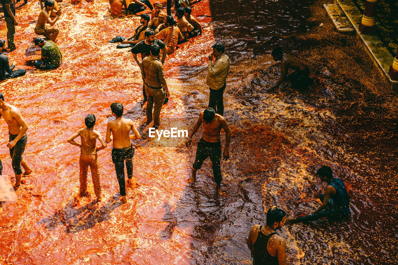 HIGH ANGLE VIEW OF PEOPLE STANDING IN WATER