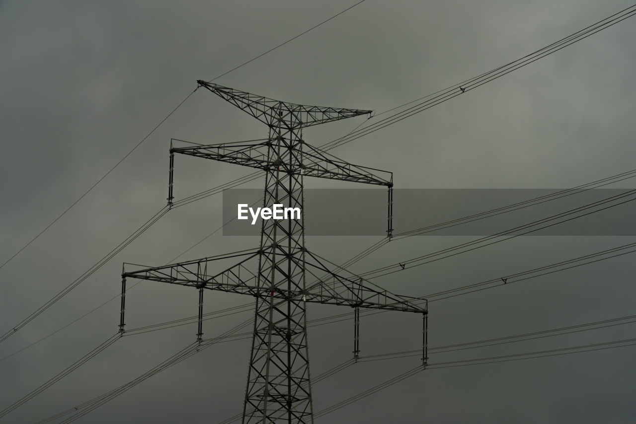 low angle view of electricity pylons against sky