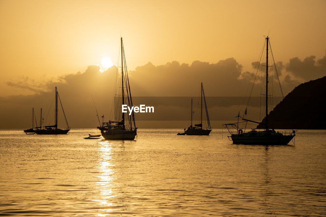 SAILBOATS IN SEA AGAINST SKY DURING SUNSET