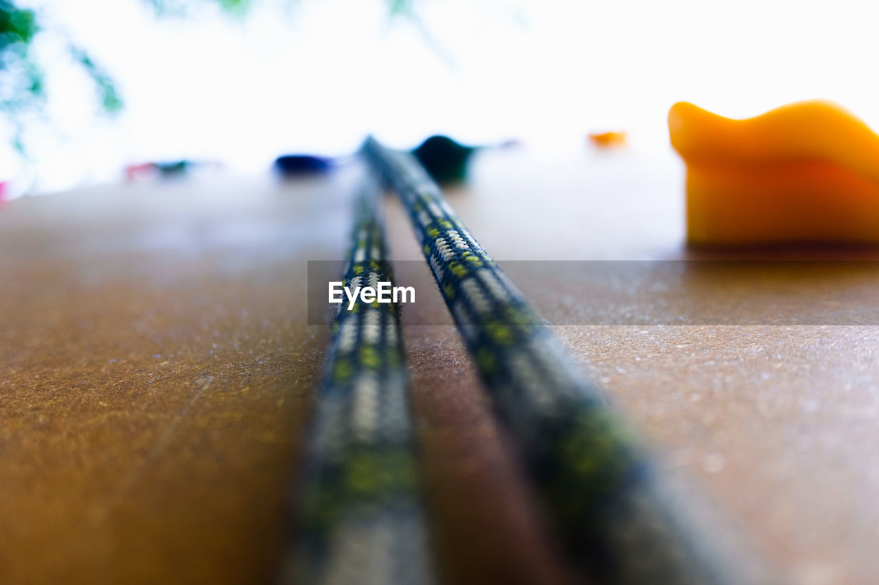 CLOSE-UP OF YELLOW PENCILS ON TABLE WITH METAL GRATE