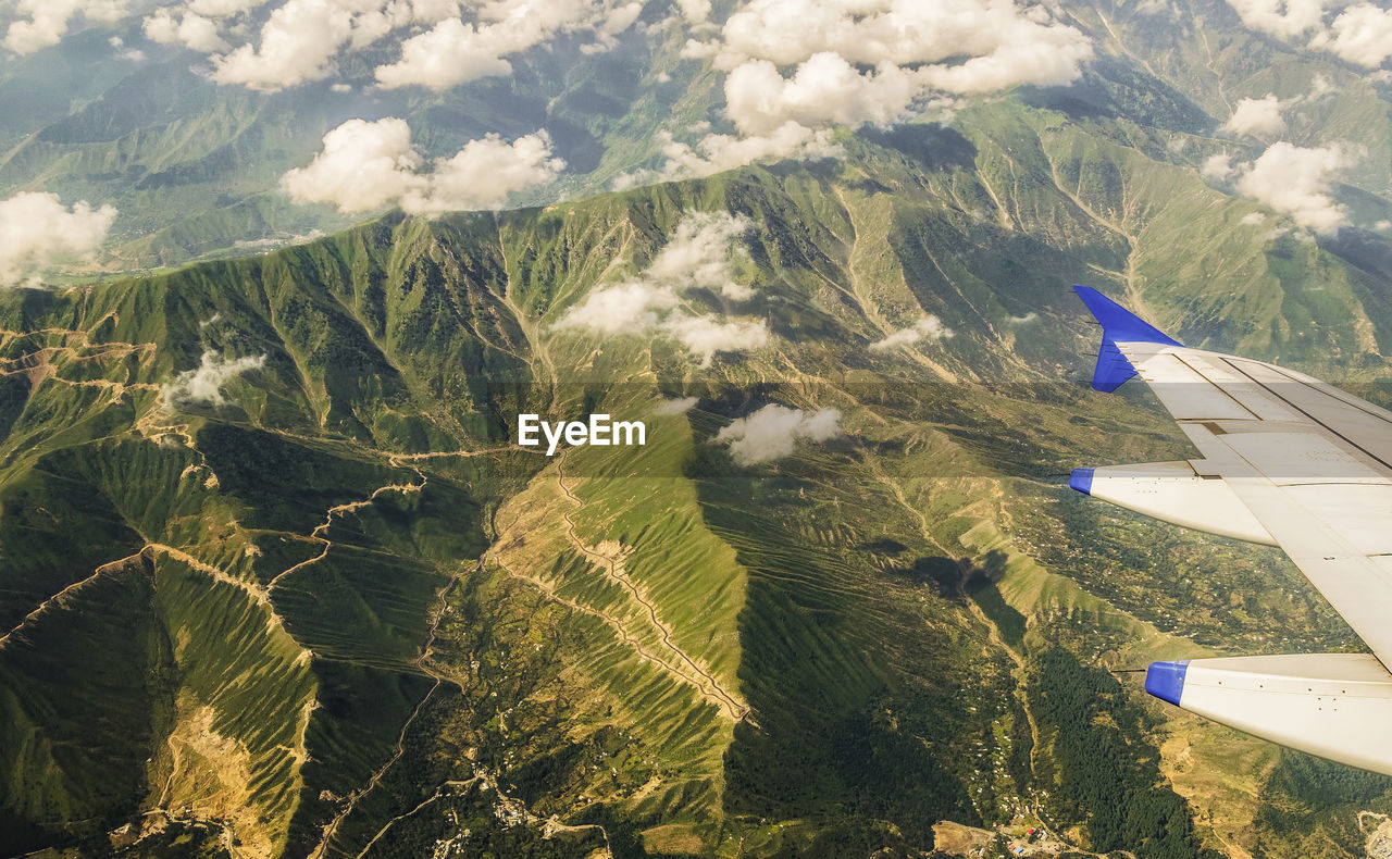 AERIAL VIEW OF LANDSCAPE AND AIRPLANE FLYING IN MOUNTAINS
