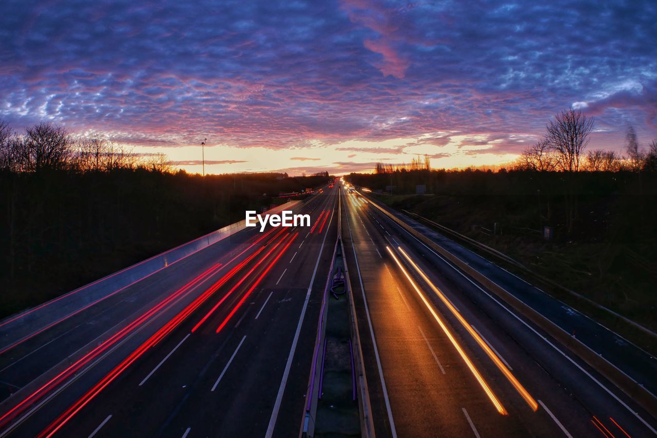 Light trails on highway at sunset