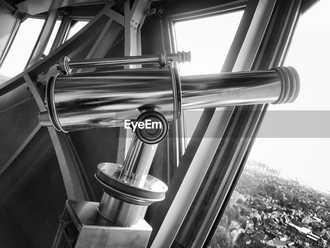 Close-up of day telescope facing townscape