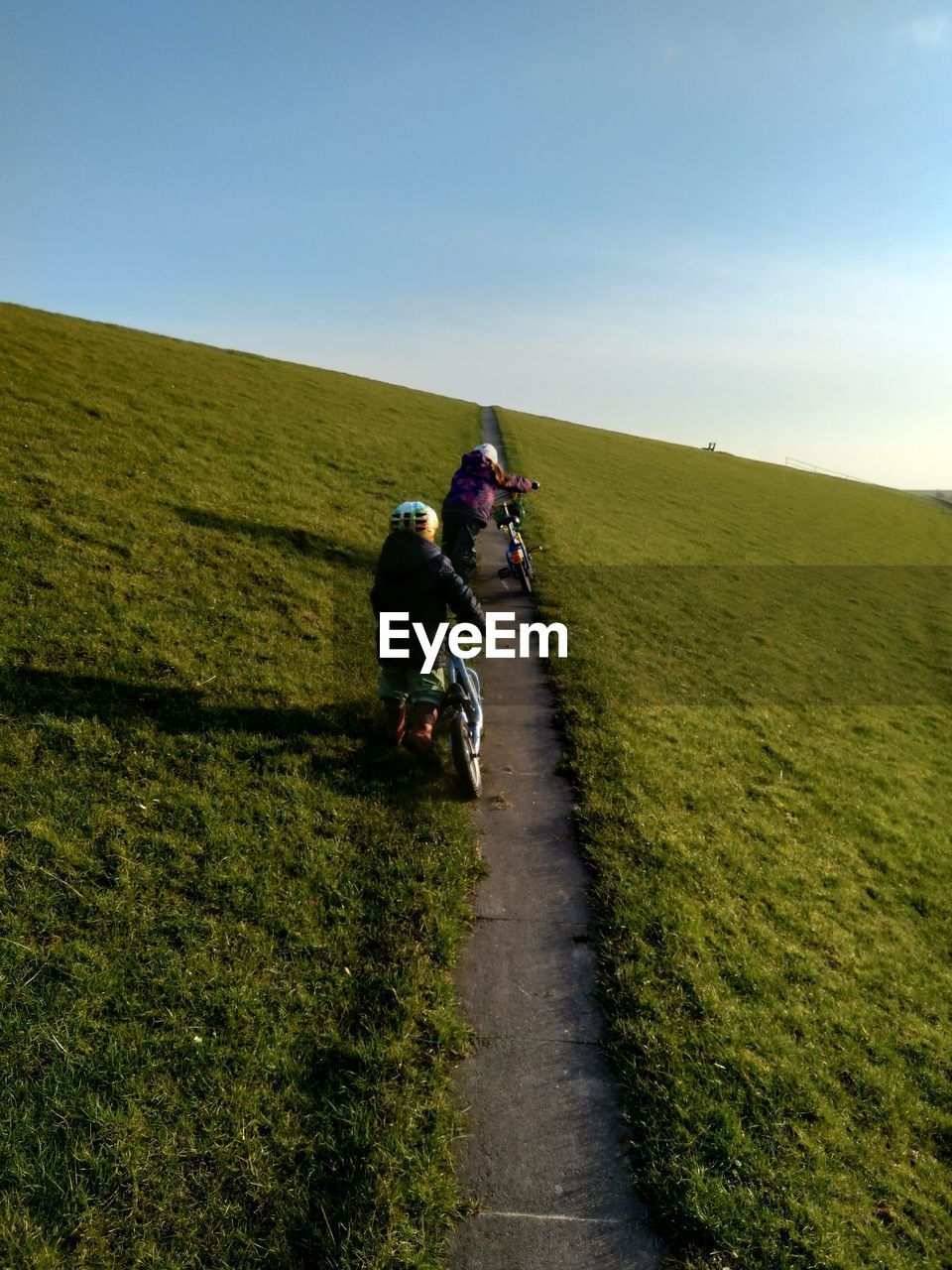 REAR VIEW OF MAN RIDING MOTORCYCLE ON FIELD