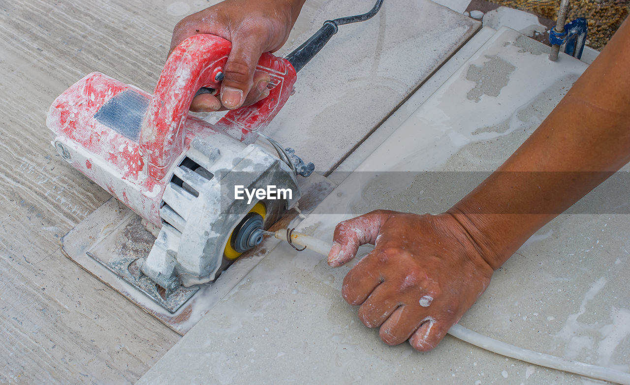 Man cutting a ceramic floor tiles