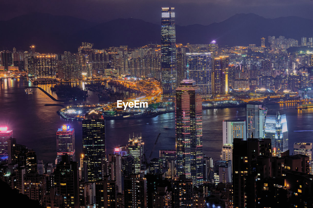 HIGH ANGLE VIEW OF ILLUMINATED BUILDINGS IN CITY AT NIGHT