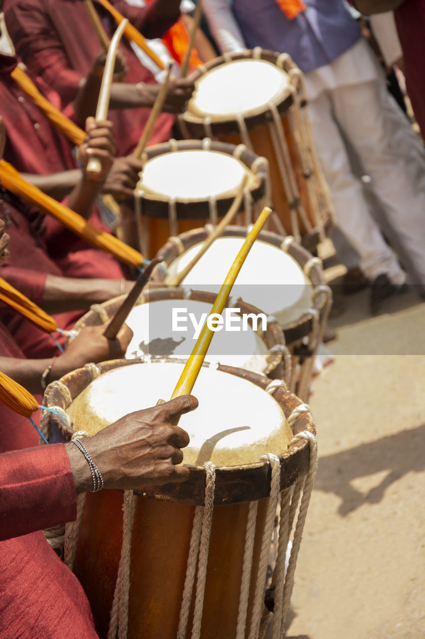 Close-up of men playing drums