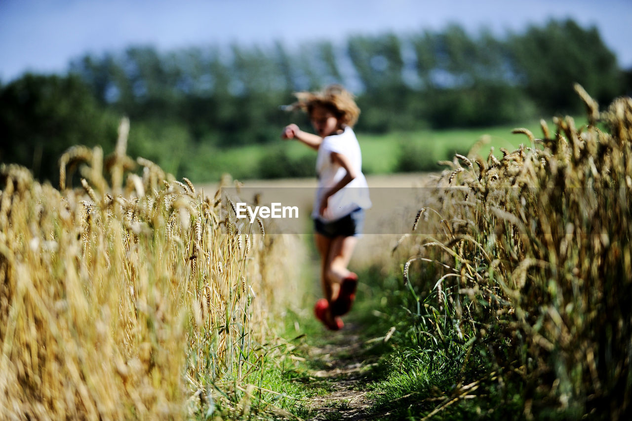 Girl running through wheat field