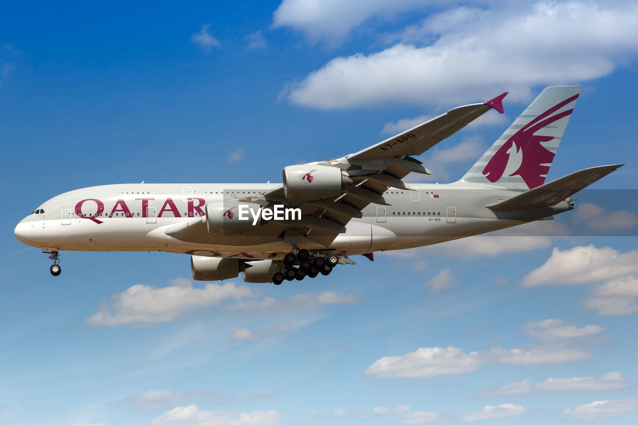 LOW ANGLE VIEW OF AIRPLANE FLYING AGAINST BLUE SKY