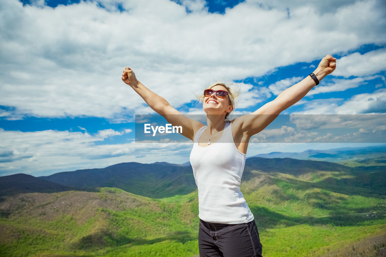 Woman standing on rock against sky