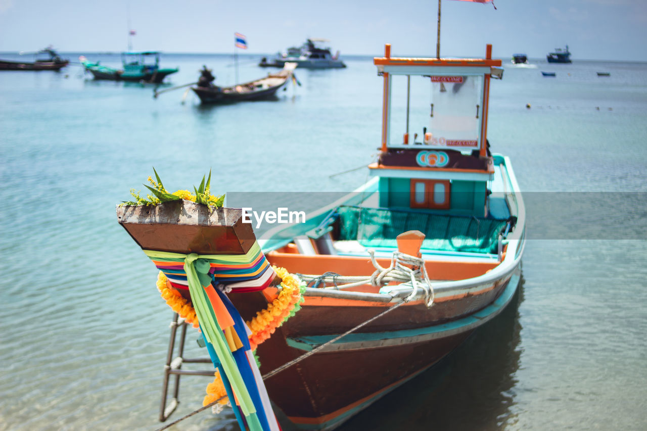 Boat moored on shore at beach against sky