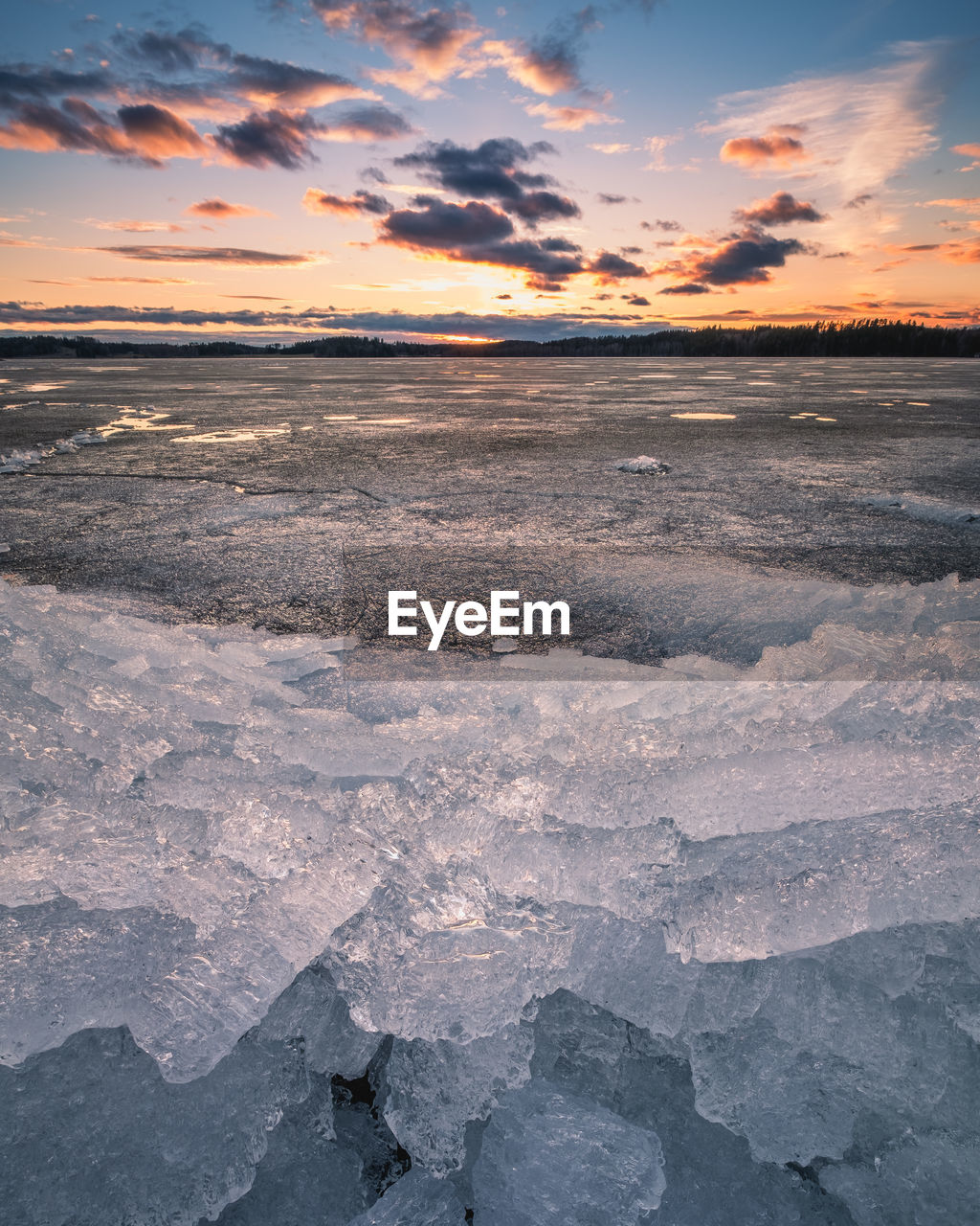 SCENIC VIEW OF FROZEN SEA AGAINST SKY DURING SUNSET