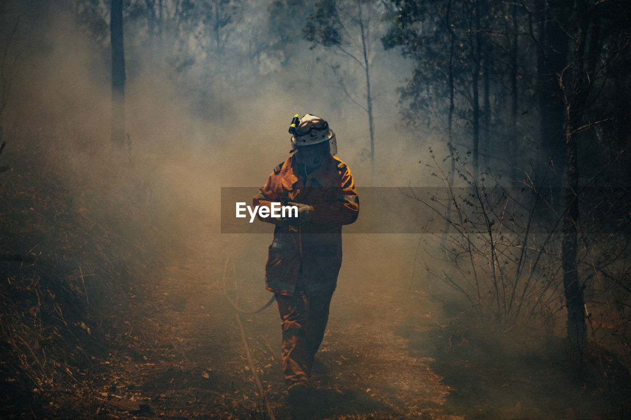 A firefighter with a hose during a large wildfire in austalia